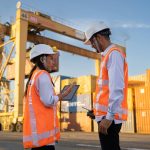 Deux inspecteurs QHSE en casque et gilet, tablette en main, sur un site industriel