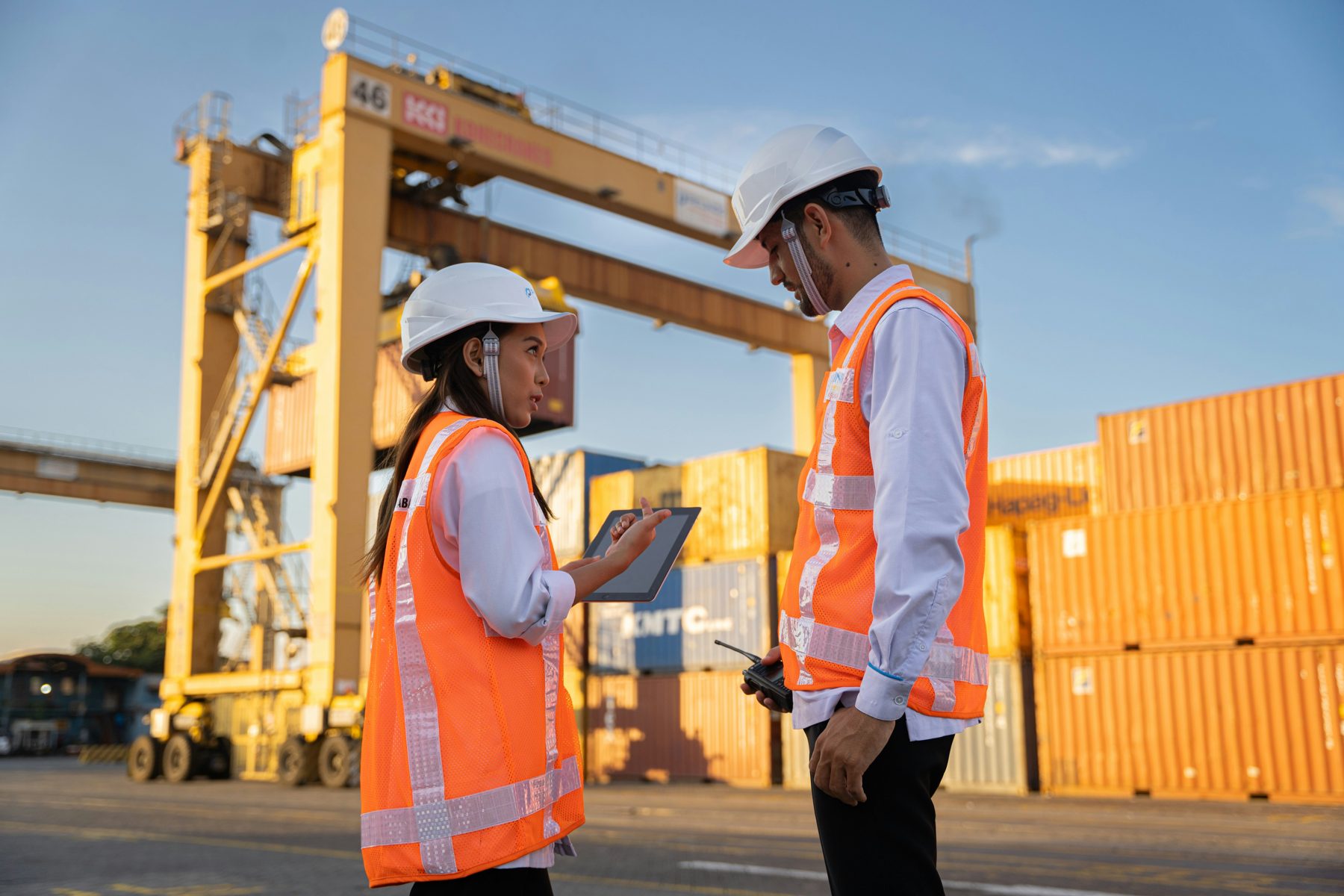 Deux inspecteurs QHSE en casque et gilet, tablette en main, sur un site industriel